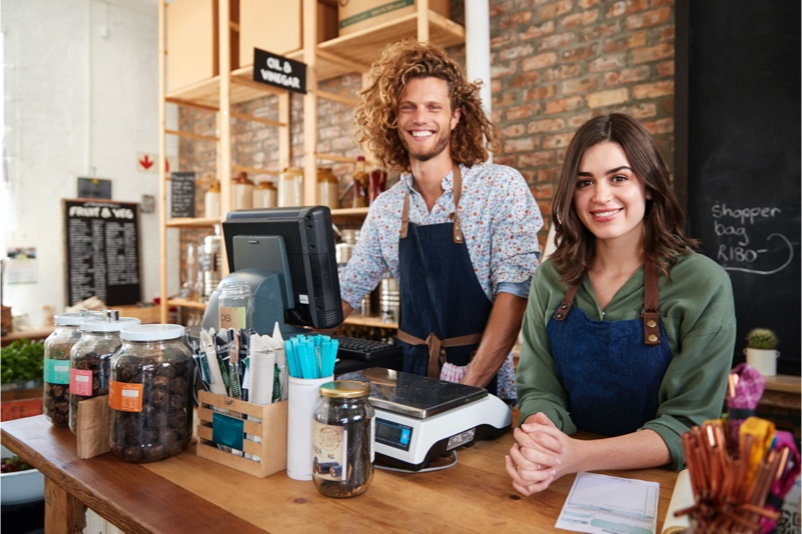 smiling man and woman behind a counter top